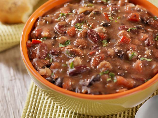 A healthy, hearty bowl of bean soup in a yellow soup mug.