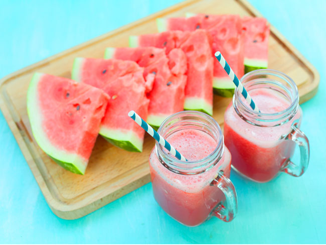 slices of watermelon next to cups of watermelon juice